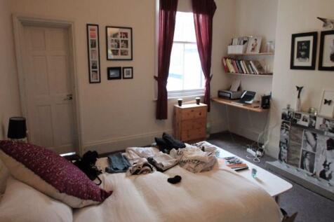 A well-lit bedroom featuring a cozy double bed ...