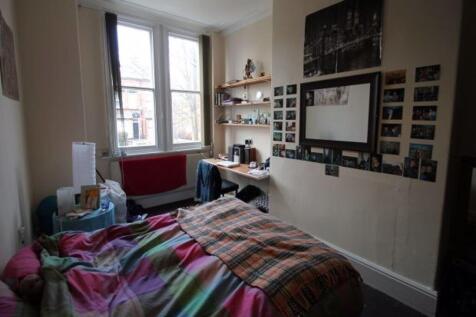 A cozy bedroom featuring a neatly made bed with...