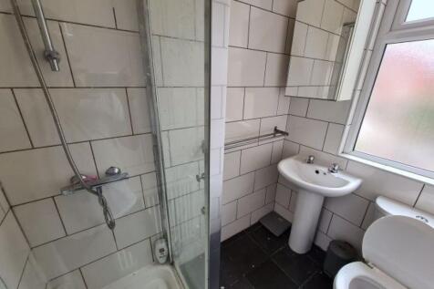 A clean and well-lit bathroom with a large show...