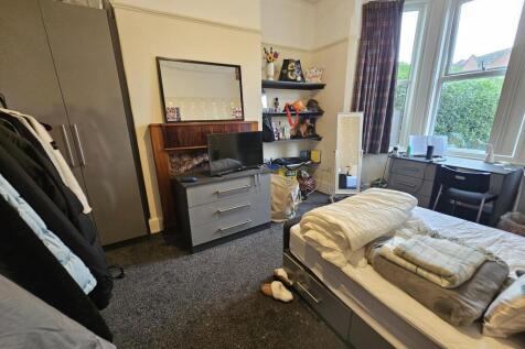 A cozy bedroom with a neatly made bed, ample na...