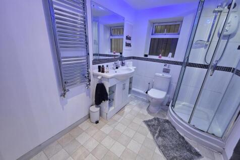 A modern, clean bathroom featuring a shower enc...