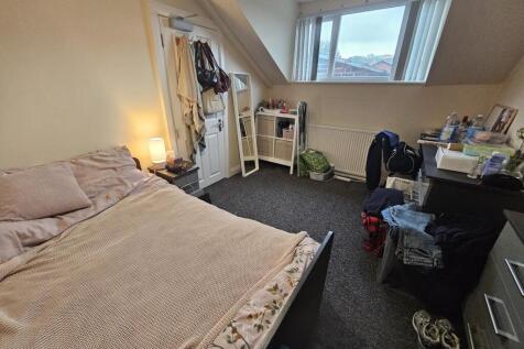 A cozy bedroom featuring a double bed, a study ...