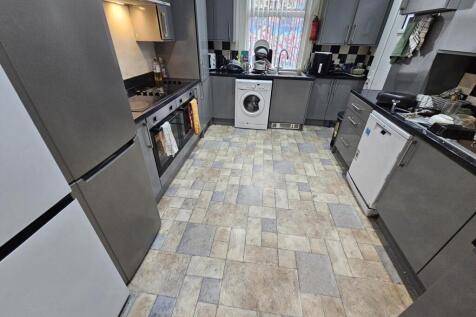 Modern kitchen with sleek grey cabinets, a vari...