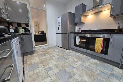 Modern fitted kitchen with grey cabinets, integ...