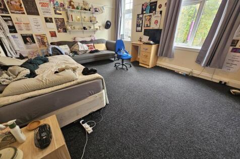 A spacious, well-lit living room featuring comf...