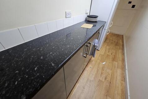 A modern kitchen with a black granite counterto...