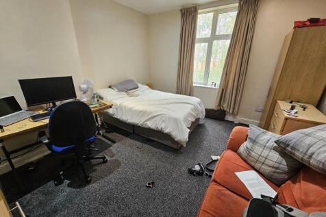 A cozy bedroom featuring a comfortable bed, a d...