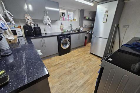 A modern kitchen featuring sleek cabinets, a re...