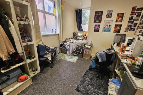 A compact bedroom with personal belongings scat...