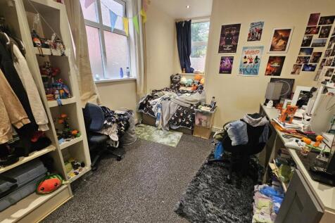 A cozy bedroom filled with personal belongings,...