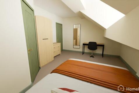 A well-maintained bedroom with a comfortable be...