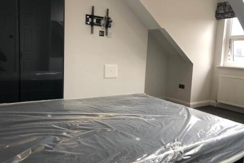 A well-lit bedroom with large windows and moder...