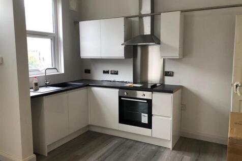 A modern, well-lit kitchen featuring white cabi...