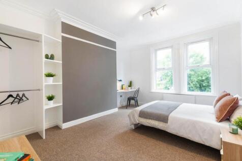 Bright and spacious master bedroom with large w...