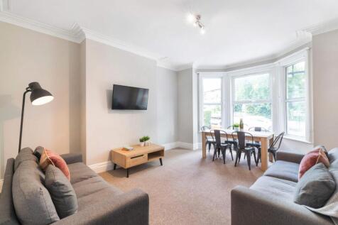 A bright and welcoming living room with large w...