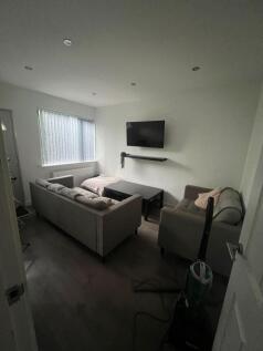 Contemporary living room with a wall-mounted TV...