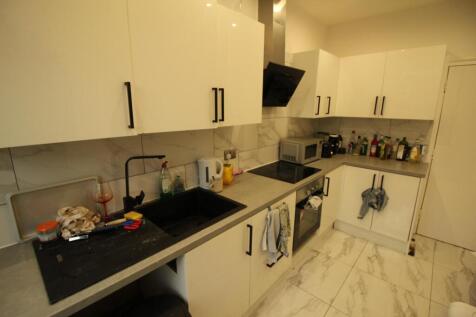 Modern fitted kitchen with white cabinetry, int...