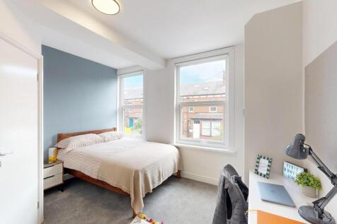 A bright and inviting bedroom featuring a comfo...