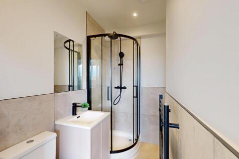 A modern and clean bathroom with a glass-enclos...