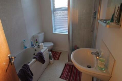 A bright and clean bathroom suite featuring a b...