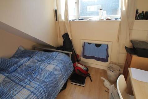 Cozy single bedroom featuring a neatly made bed...