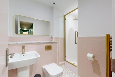 Bright, modern bathroom with pink tiled lower w...