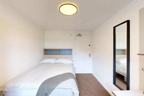 A tidy and well-lit double bedroom featuring a ...