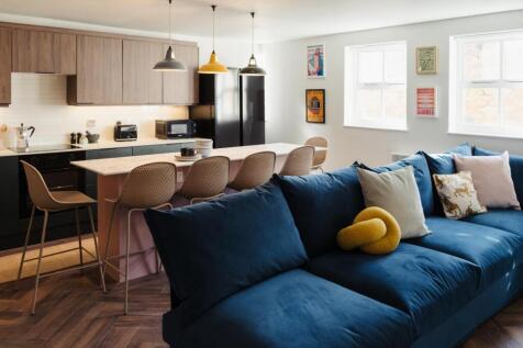A bright, spacious living room featuring a deep...