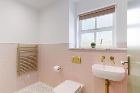 Bright, modern bathroom with soft pink tiling, ...