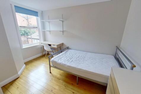 Bright and clean student bedroom featuring a si...