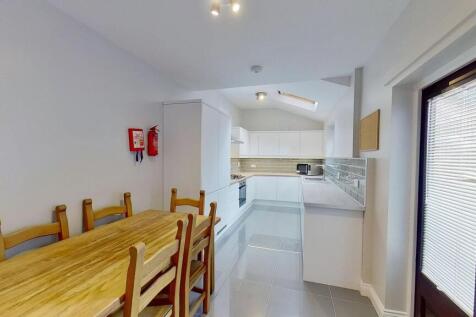 Bright and modern kitchen featuring white cabin...