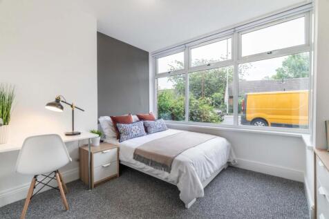 A bright, spacious master bedroom featuring a l...