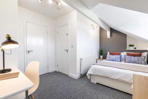 A bright and airy bedroom featuring a comfortab...