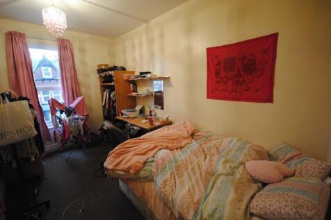 A cozy bedroom featuring a single bed with colo...