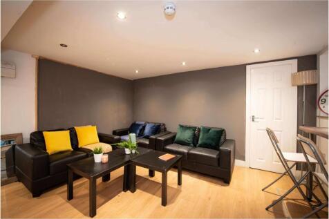 A spacious, well-maintained living room featuri...