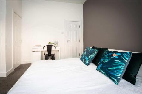 A modern, spacious master bedroom featuring lar...