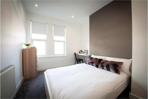 A bright and clean bedroom featuring a comforta...