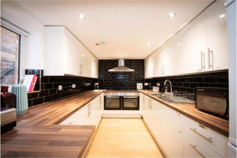 A modern kitchen with sleek black and white cab...