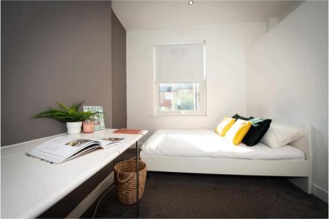 A bright and tidy single bedroom with a comfort...