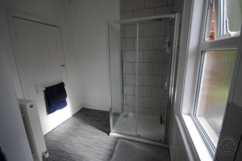 A clean and functional bathroom with a glass-en...