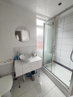 Bright, modern bathroom with a glass-enclosed s...