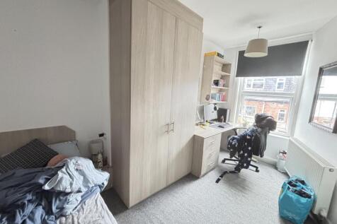 Bright single bedroom with a window-facing stud...