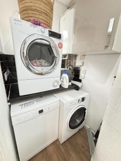 Compact, well-maintained utility area with stac...