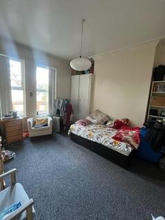 A spacious master bedroom featuring a large bed...