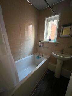 A clean and functional bathroom with a bathtub,...