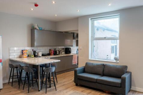 A modern, well-lit living room featuring a dark...