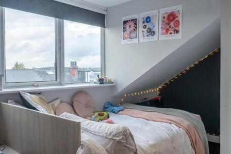 A bright and cozy bedroom featuring large windo...