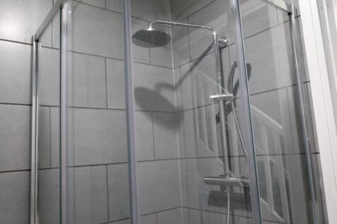 A clean and modern bathroom with a large shower...
