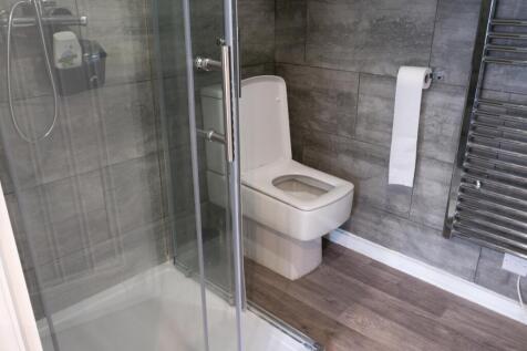 A modern bathroom featuring a large toilet with...