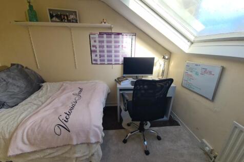 A cozy bedroom featuring a comfortable bed with...